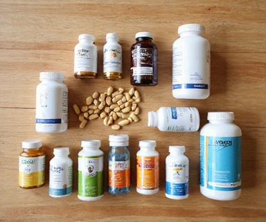 Vitamins and supplements arranged on a wooden surface for men's wellness routine